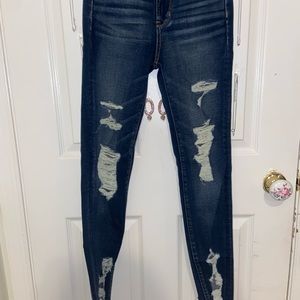 A pair of dark wash distressed jeans
